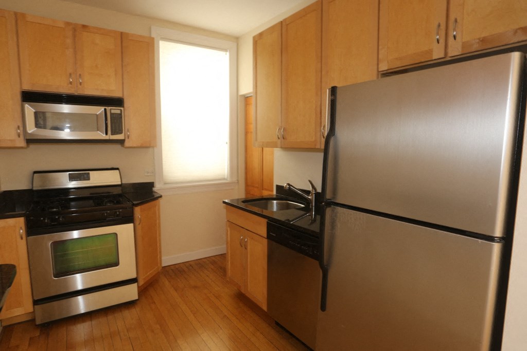 a kitchen with stainless steel appliances and wooden cabinets
