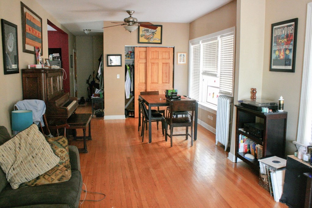 a living room and dining room with wood floors and a piano