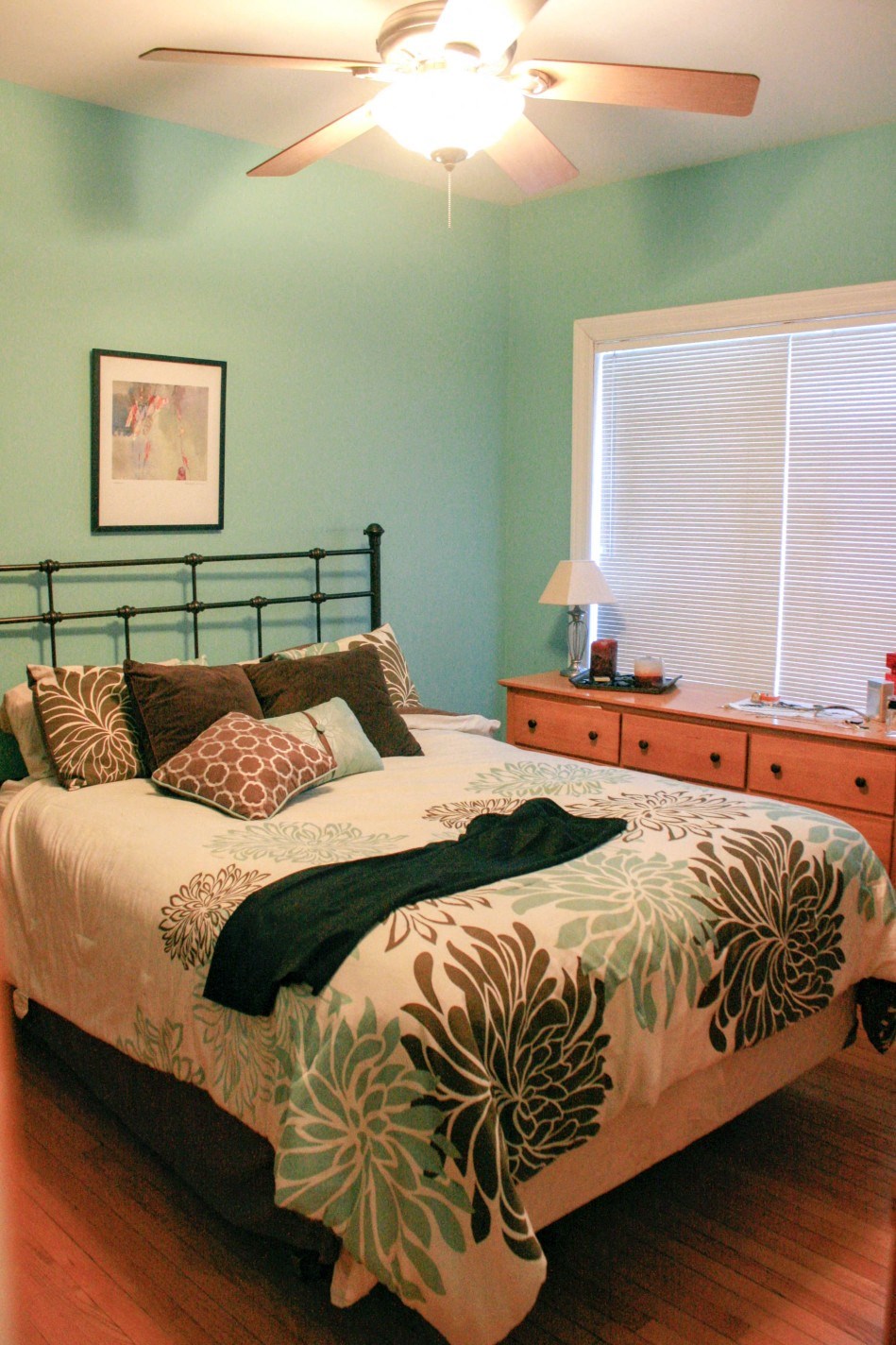 a bedroom with a bed and a dresser and a ceiling fan