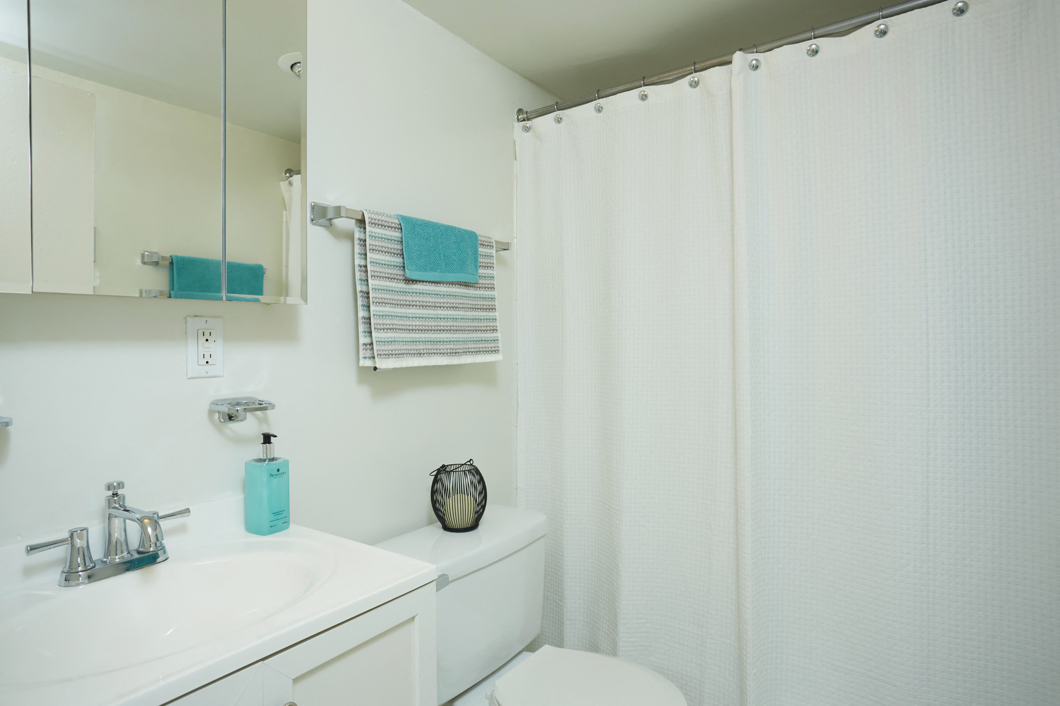 a bathroom with a shower and a sink and a toilet