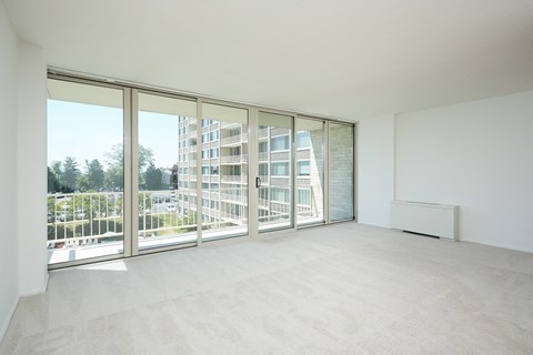an empty living room with sliding glass doors and a balcony