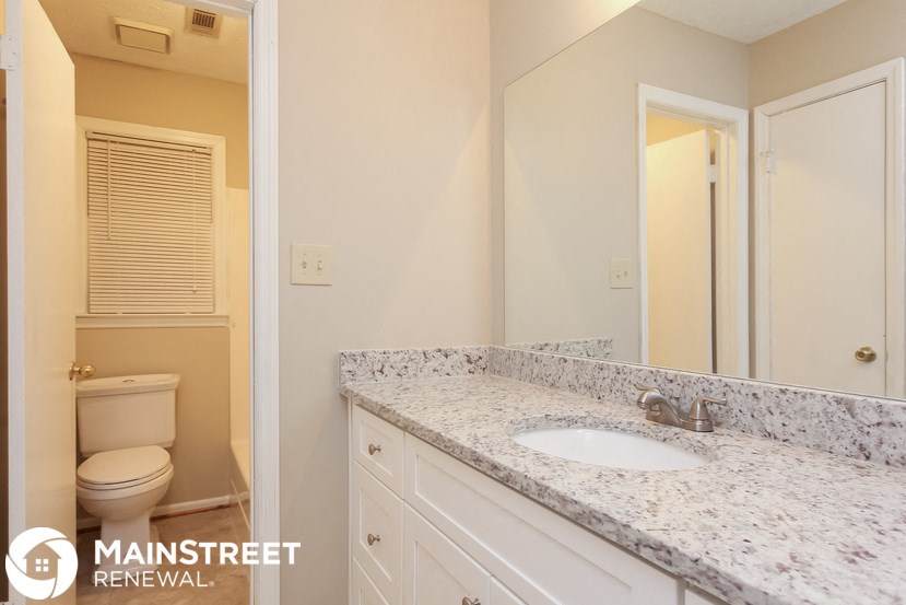 a bathroom with a sink and a toilet and a mirror