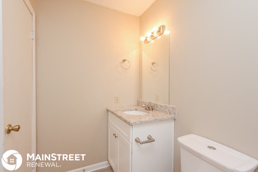 a bathroom with a toilet and a sink and a mirror