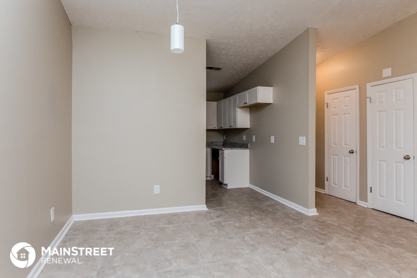 the spacious living room and kitchen with stainless steel appliances