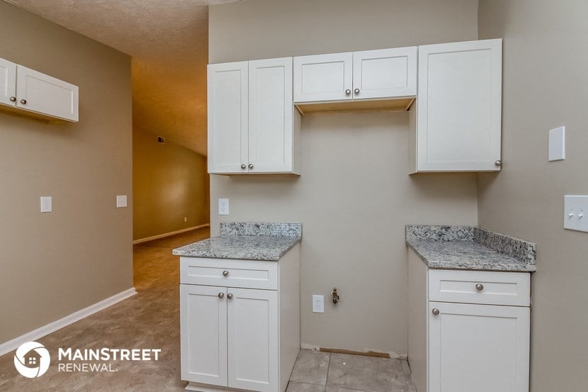 a kitchen with white cabinets and granite counter tops