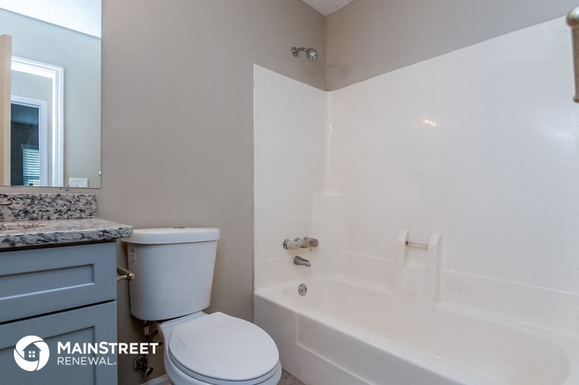 a bathroom with a tub and a toilet and a sink