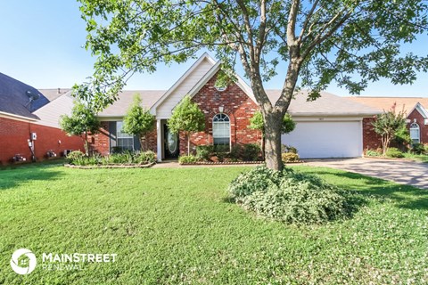 a house with a lawn and a tree in front of it