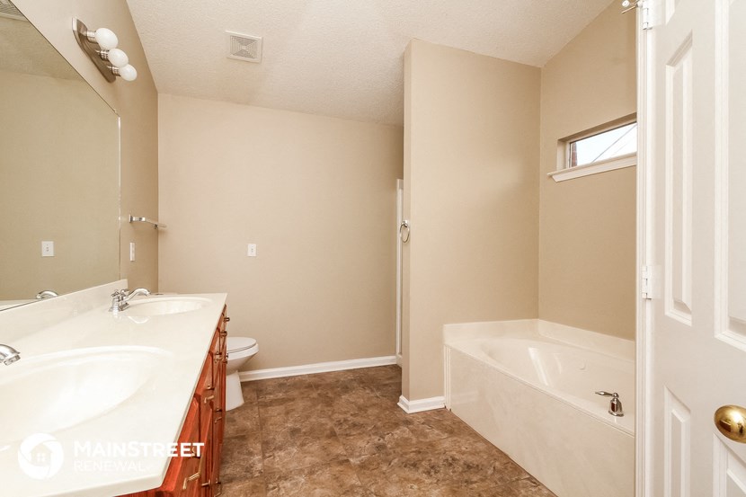 a bathroom with a tub and a sink and a toilet