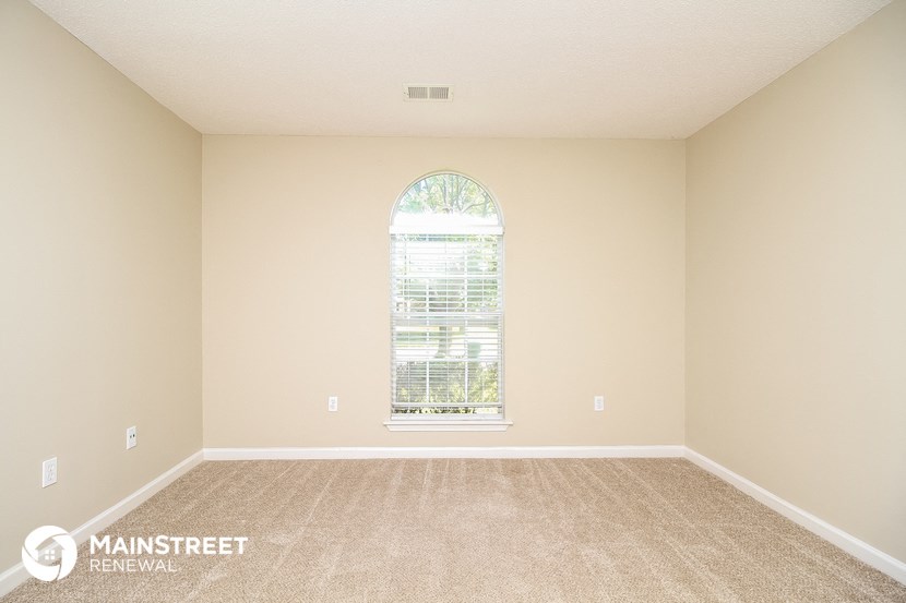 a spacious living room with carpet and a large window
