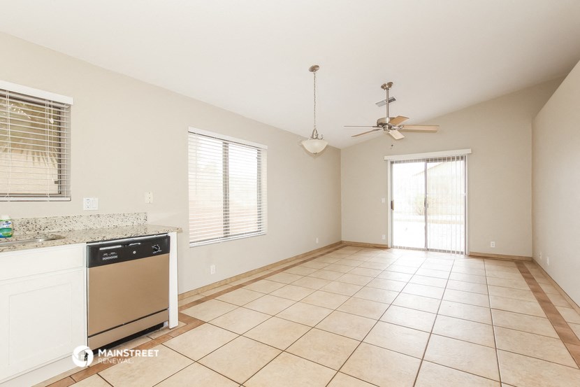 an empty kitchen and living room with a ceiling fan
