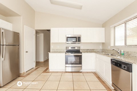 a kitchen with white cabinets and stainless steel appliances