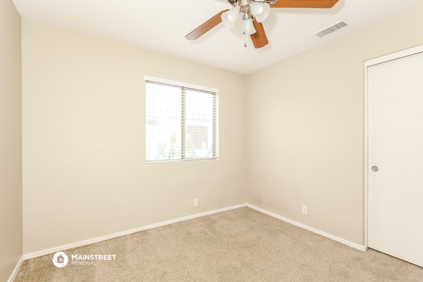 a bedroom with a ceiling fan and a window