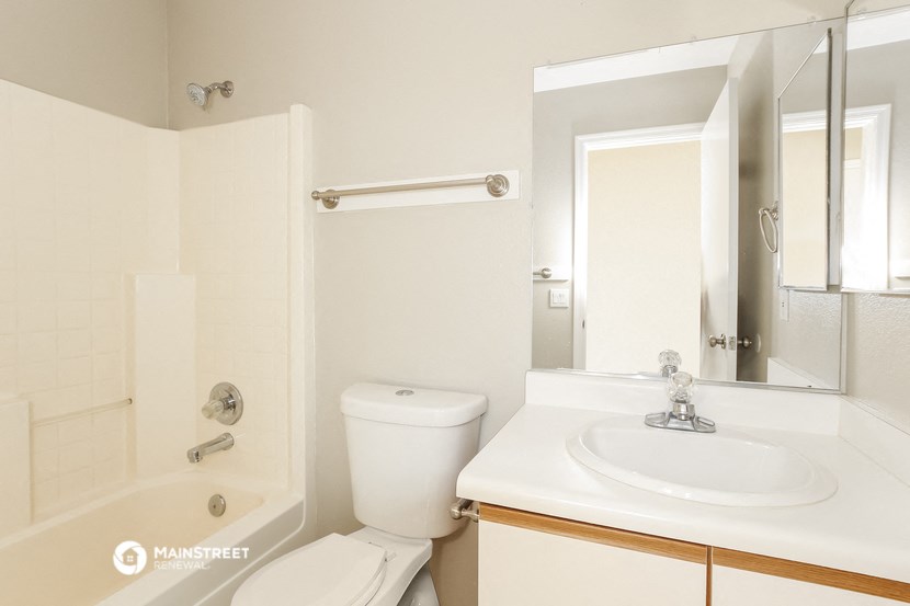 a bathroom with a sink toilet and shower and a mirror