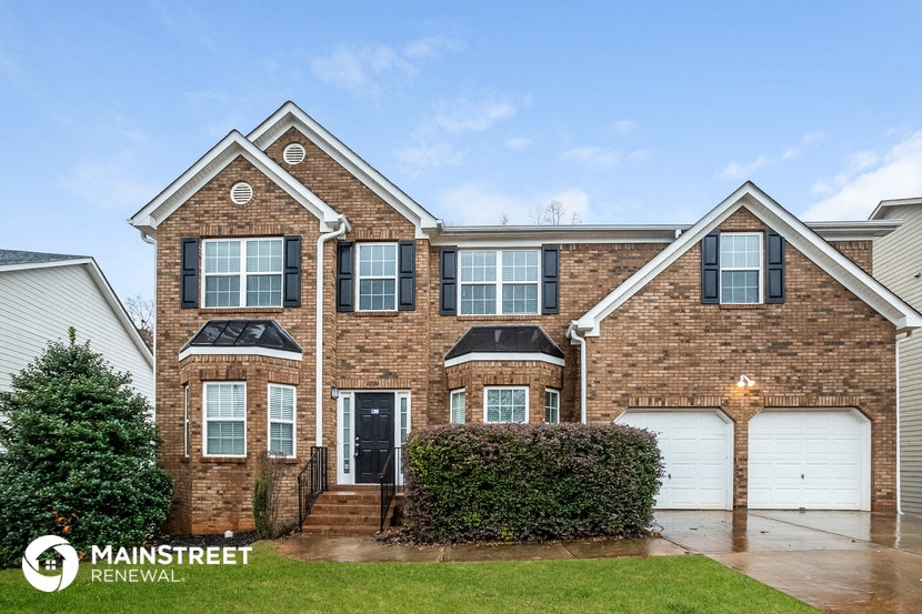 front view of a brick house with white garage doors