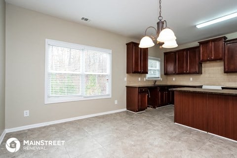 a kitchen with wooden cabinets and a large window