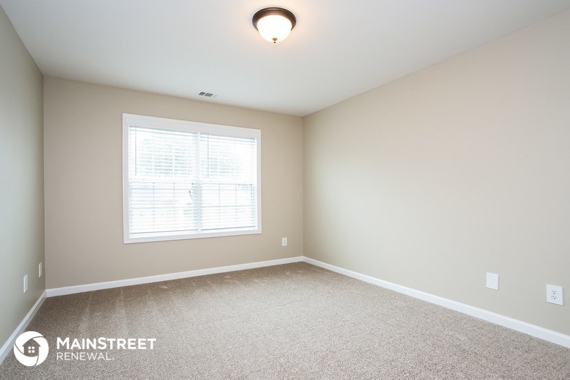 the master bedroom is spacious and updated with carpeting and a large window