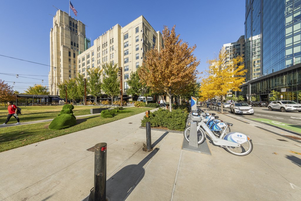 A bike is parked on a sidewalk in front of a tree.