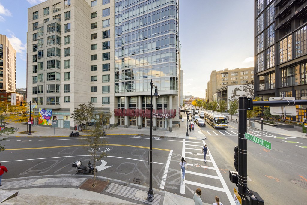 A city street with a crosswalk and a green street sign.