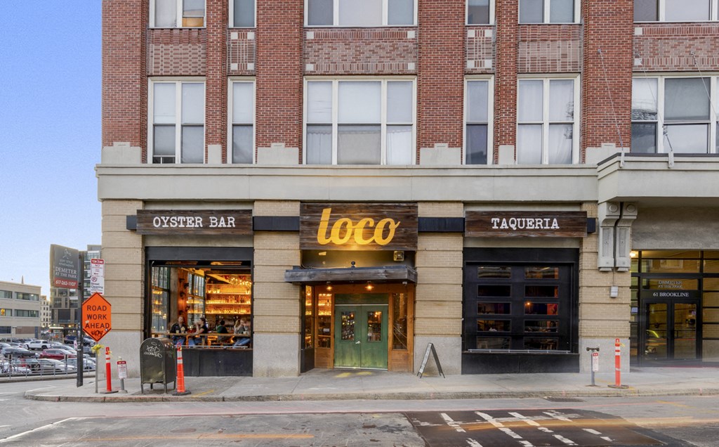 A building with a red brick facade has a sign that says LOCO.