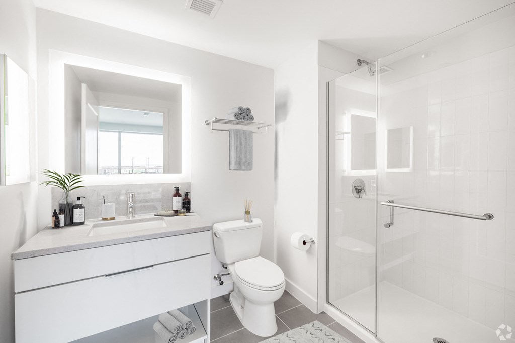 A white bathroom with a toilet, sink, and shower.