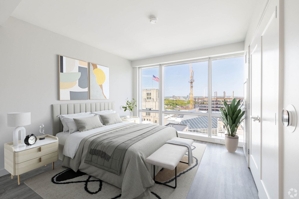 A bedroom with a large bed and a view of the city.