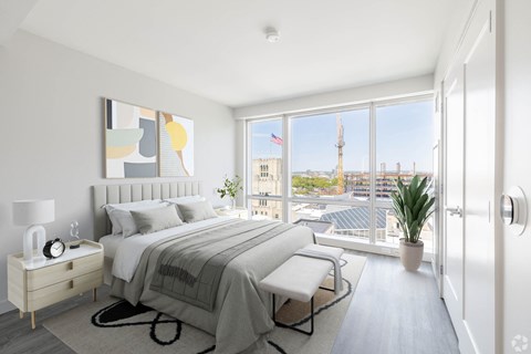 A bedroom with a large bed and a view of the city.