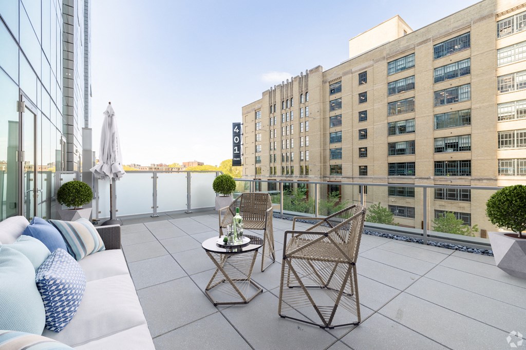 A balcony with two chairs and a table.