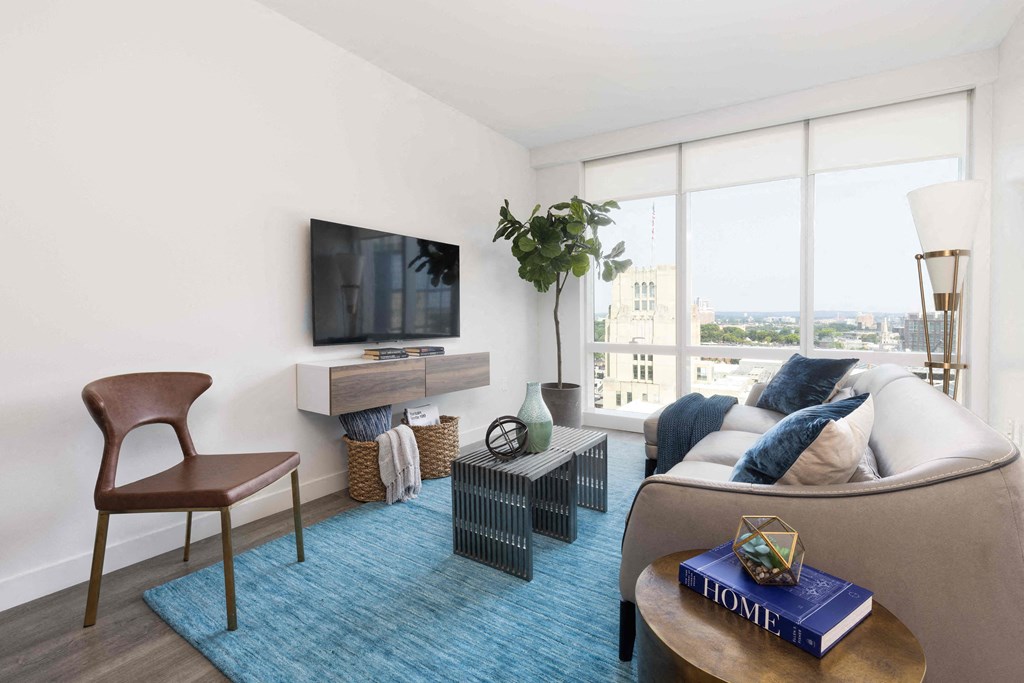 a living room with a blue rug and a couch and a television