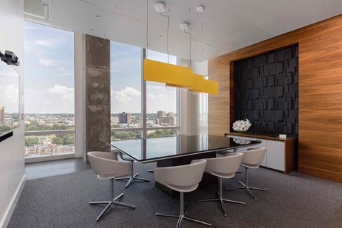 a conference room with a glass table and chairs and a large window