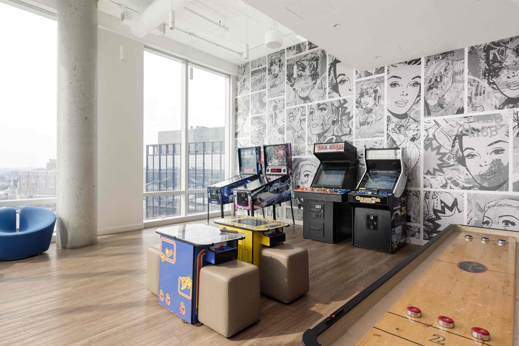 a room with arcade games and a wall covered in black and white wallpaper