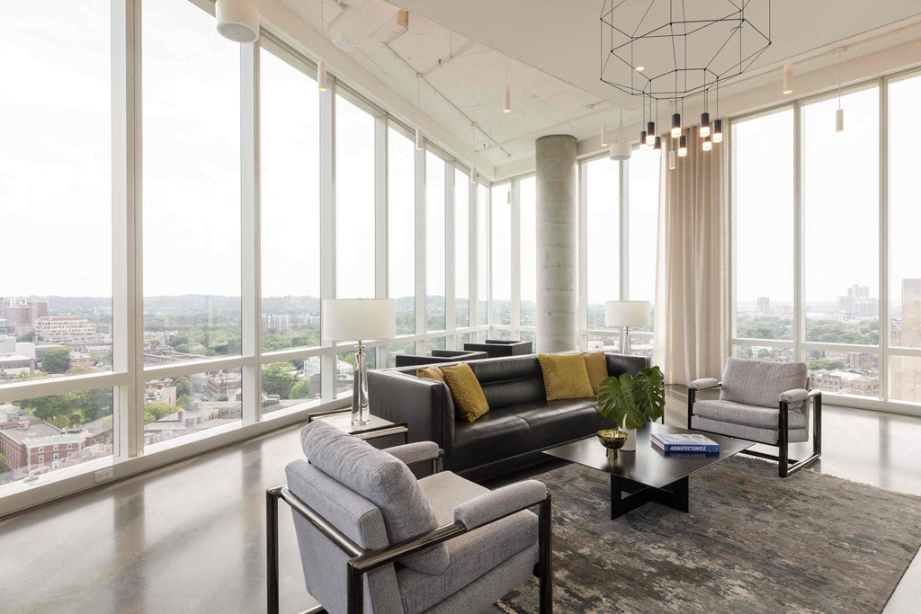 a living room with a view of a city and couches and chairs
