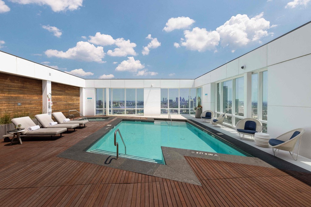a swimming pool on the top of a skyscraper with glass windows