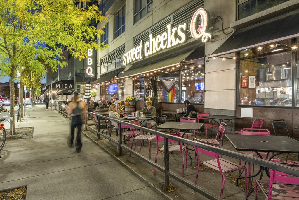 A restaurant named Sweet Cheeks is located on a busy street corner.