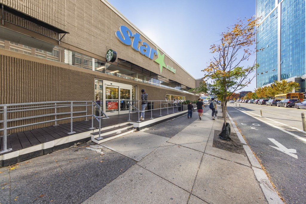 A Starbucks coffee shop is located on a sidewalk in front of a building.