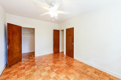 an empty living room with wood flooring and a ceiling fan