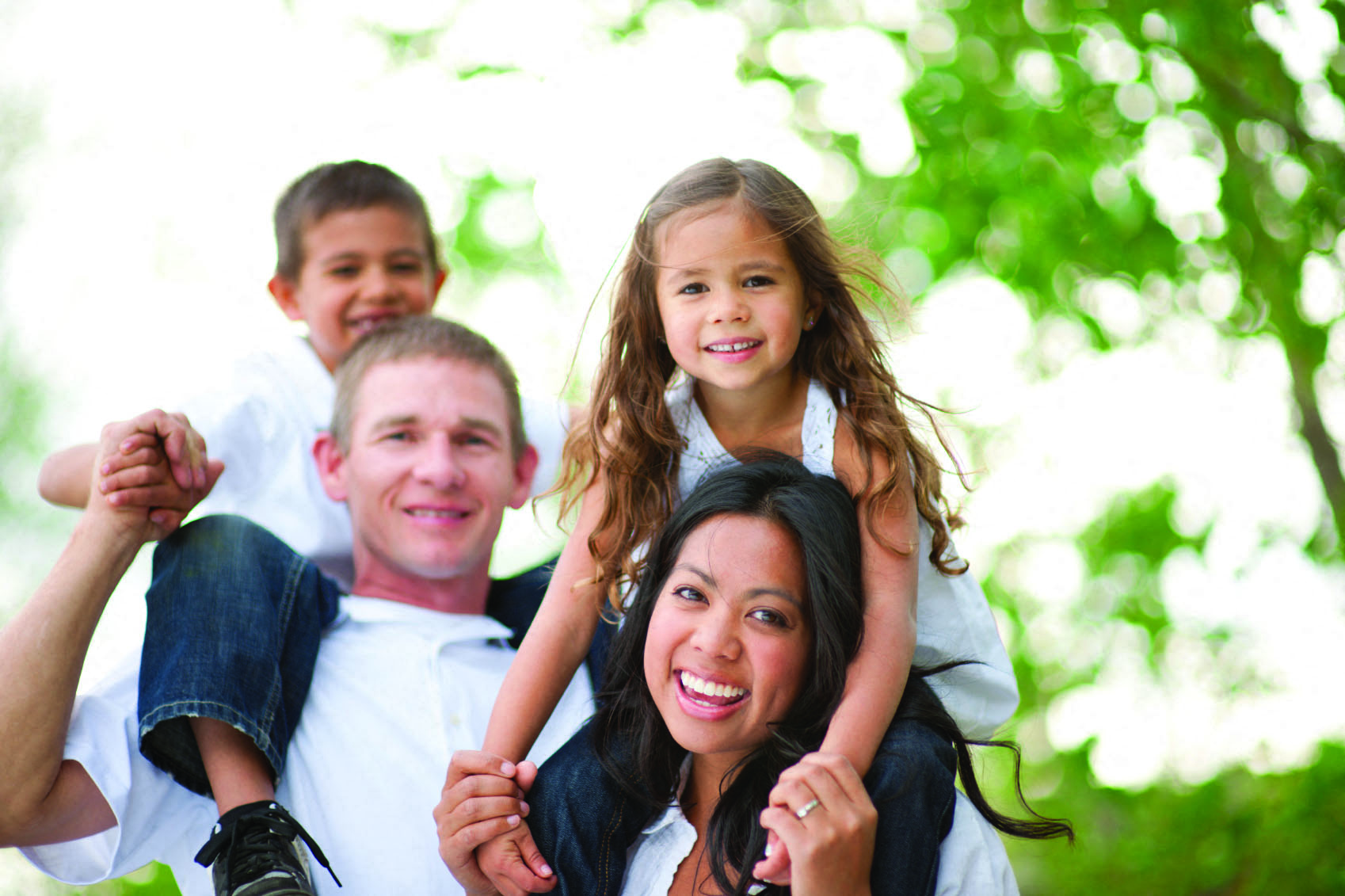 a family is posing for a picture with their daughter on their shoulders
