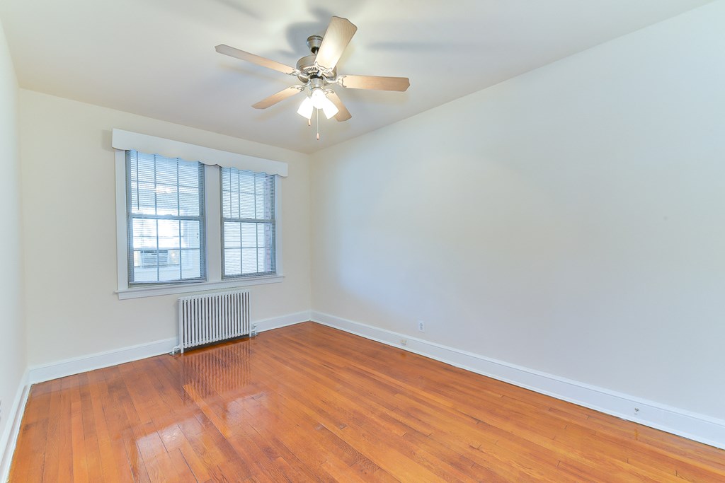 vacant bedroom with hardwood flooring, large windows and ceiling fan at 4020 calvert street apartments in washington dc