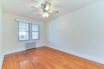 vacant bedroom with hardwood flooring, large windows and ceiling fan at 4020 calvert street apartments in washington dc - Photo Gallery 5