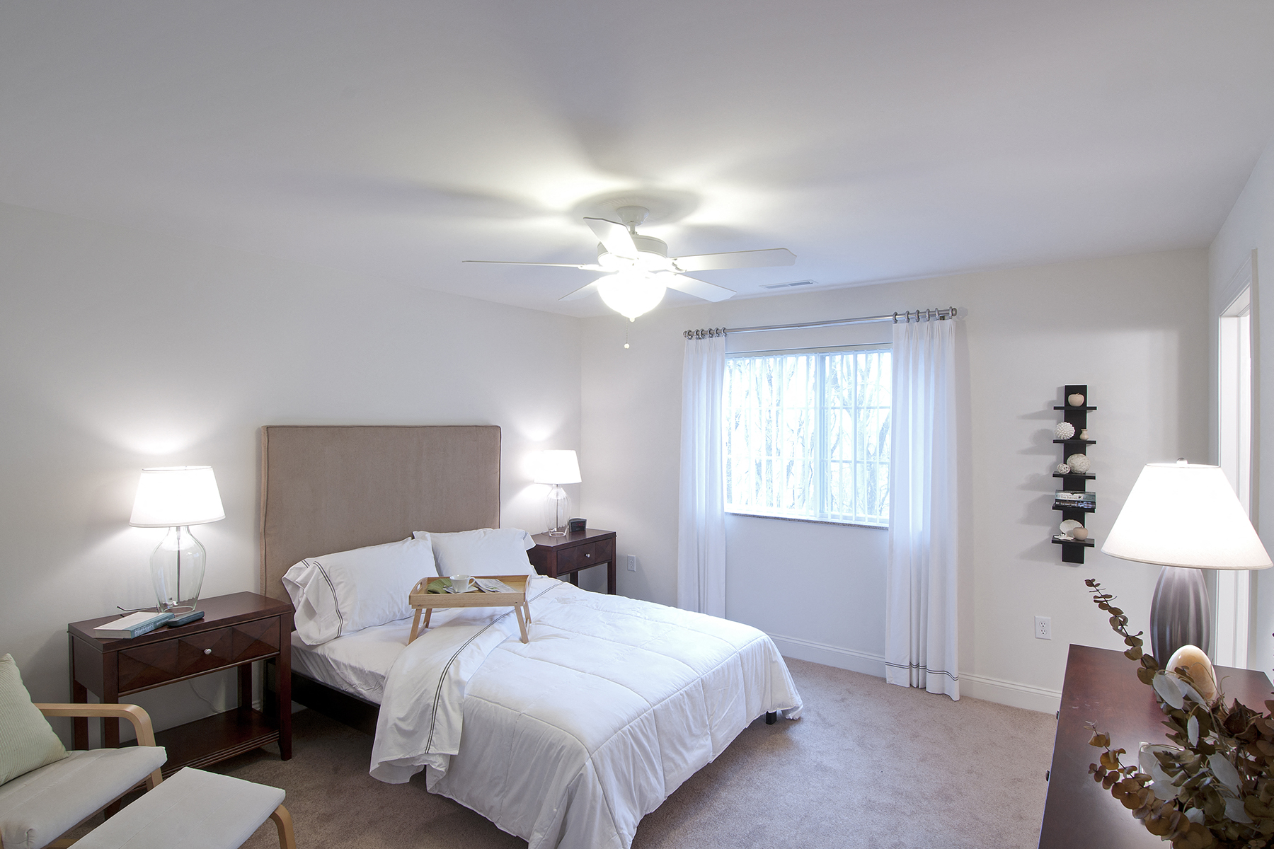 a bedroom with a bed and a ceiling fan