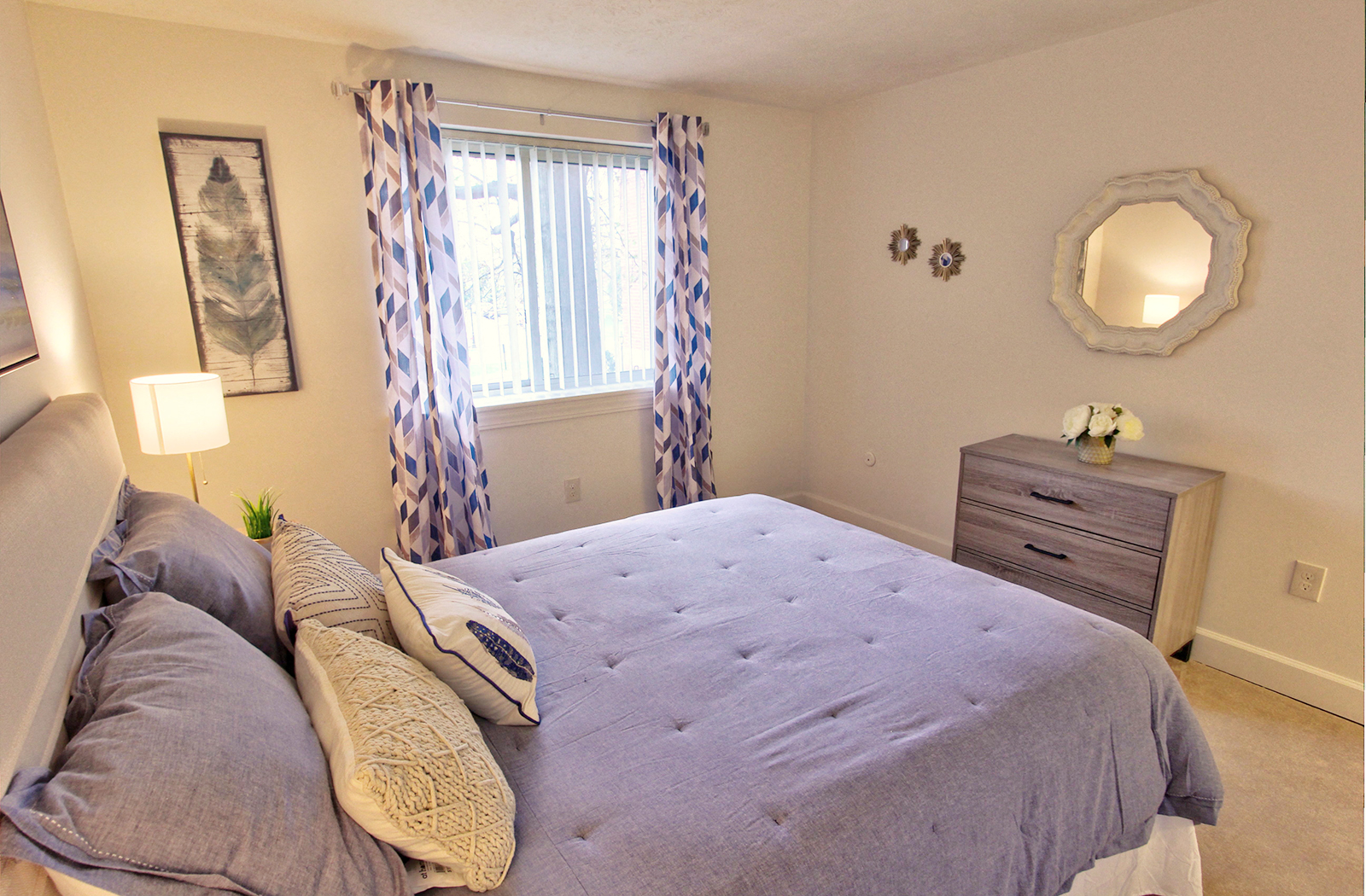 a bedroom with a bed and curtains and a mirror