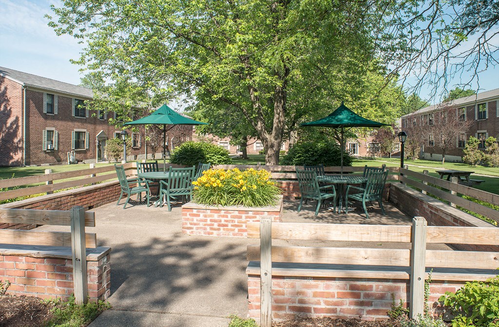 a patio with tables and chairs in a courtyard