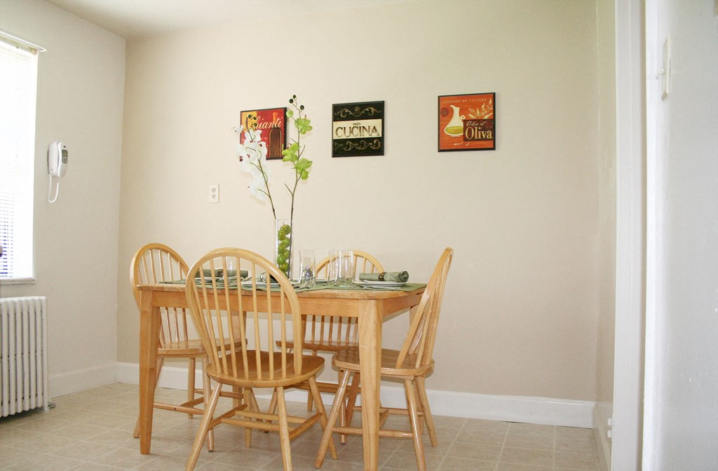 a dining room with a wooden table and chairs