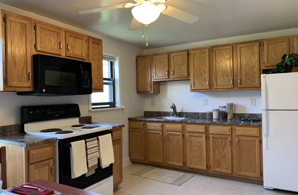 a kitchen with wooden cabinets and a stove and a microwave