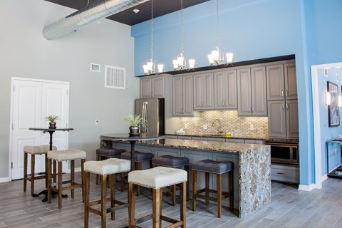 a kitchen with an island with bar stools and gray cabinets