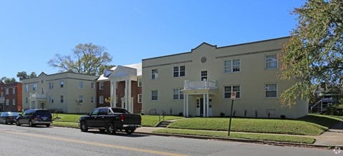 a row of three story apartment buildings on the side of a street