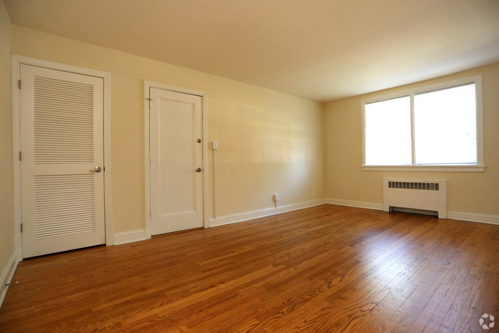 the living room of an empty house with wood floors and a door