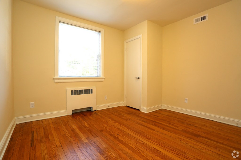 a empty room with wooden floors and a window