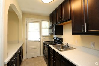 a kitchen with black cabinets and a sink and a door
