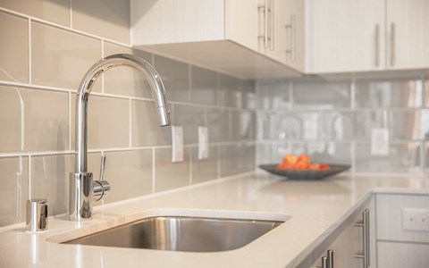 a white kitchen with a sink and a faucet