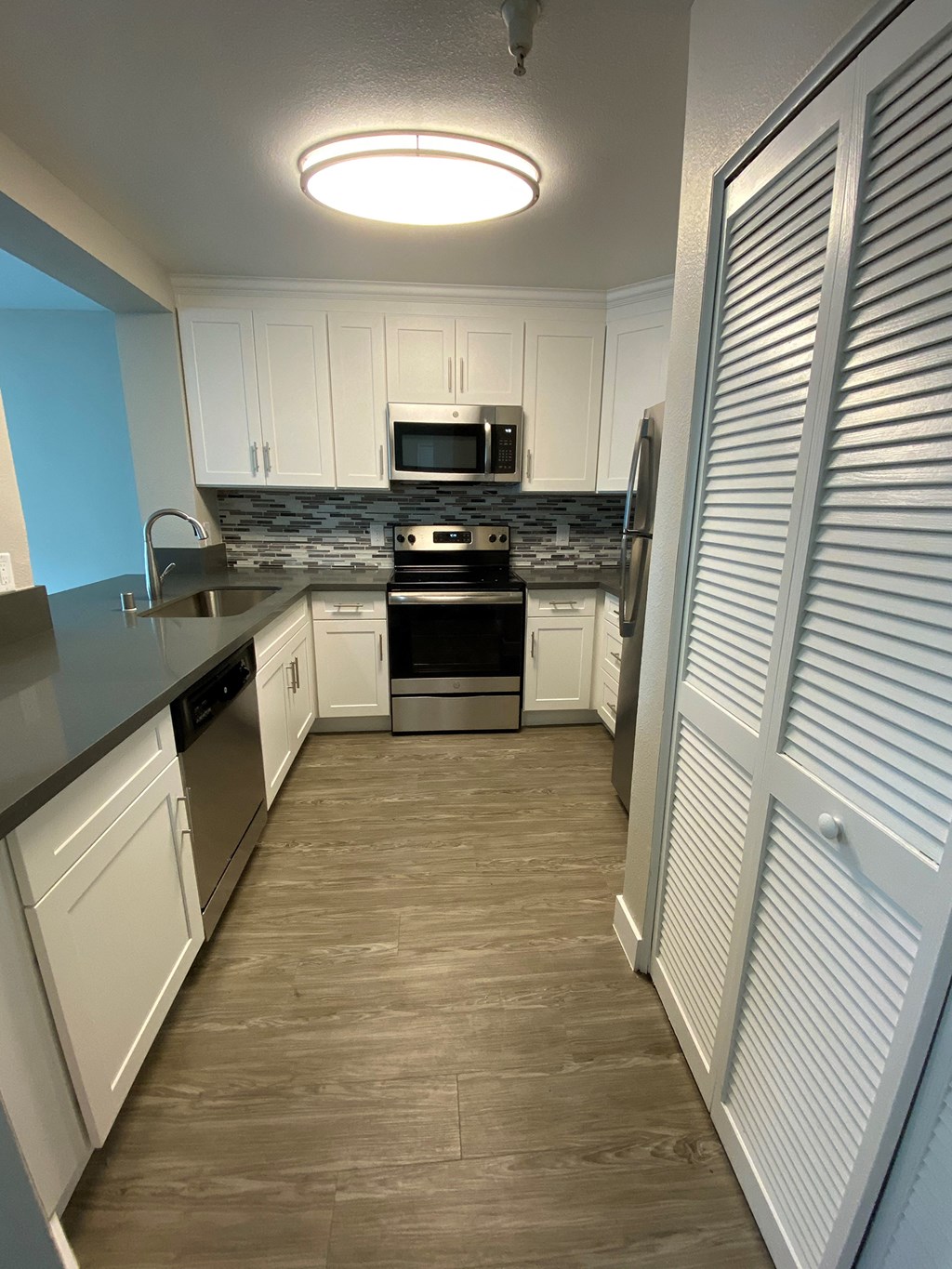 a kitchen with white cabinets and stainless steel appliances